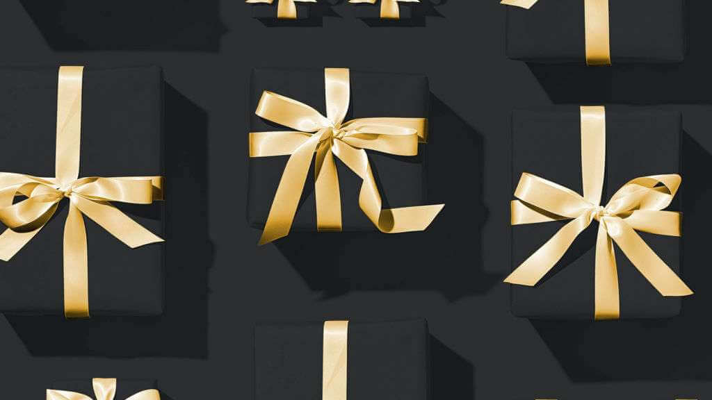 Several black gift boxes with gold ribbons, arranged in a neat pattern on a dark background, evoke an aesthetic reminiscent of TouchDesigner artistry.